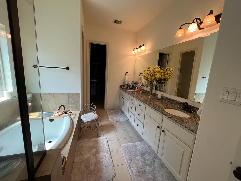 13117 Stoneleigh Terrace Drive Houston, TX 77077 - Photo 5 of 23 a bathroom with a double vanity sink a mirror and a shower
