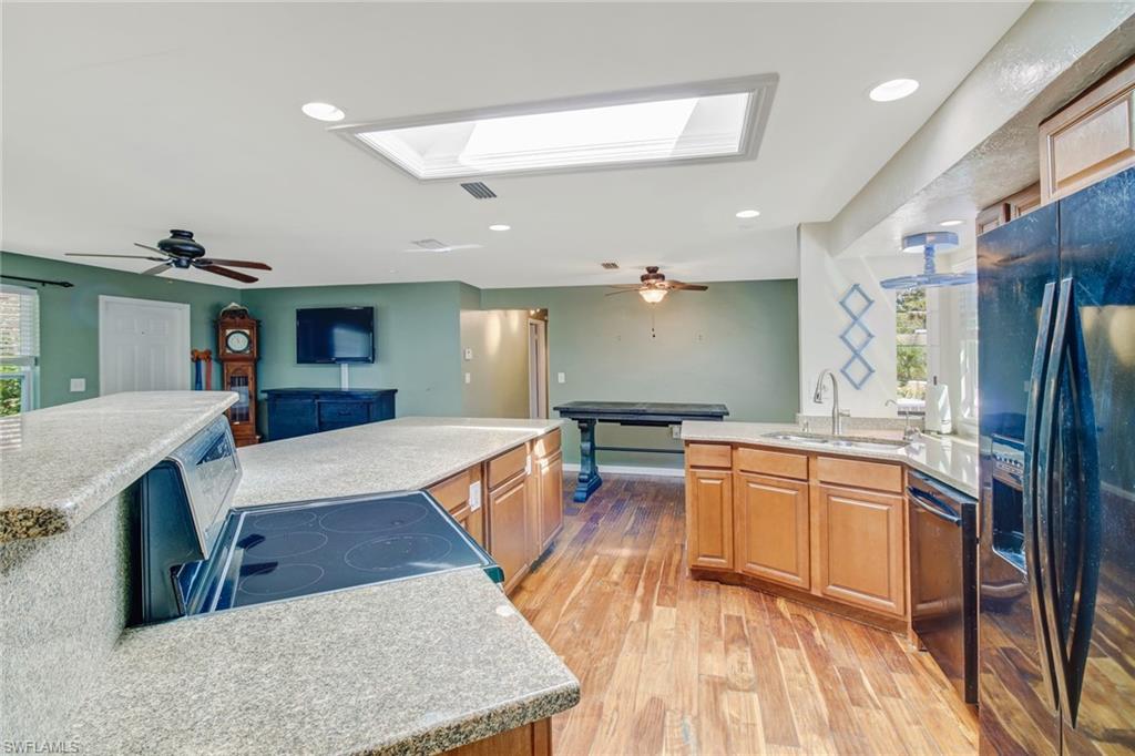 842 Roseate Drive Naples, FL 34104 - Photo 11 of 33 a large kitchen with kitchen island a large counter top space a sink stainless steel appliances and cabinets