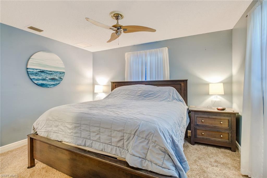 842 Roseate Drive Naples, FL 34104 - Photo 15 of 33 a bedroom with a bed and a chandelier