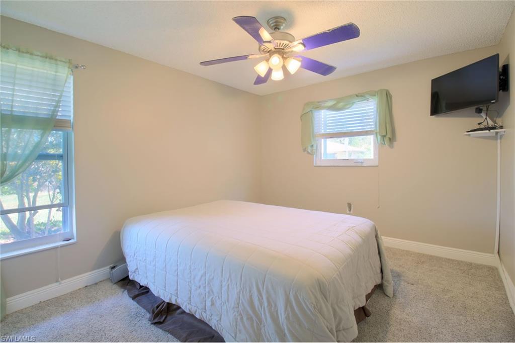 842 Roseate Drive Naples, FL 34104 - Photo 20 of 33 a bedroom with a bed and a flat screen tv
