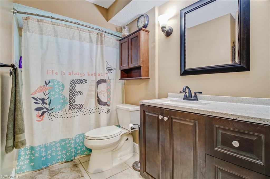 842 Roseate Drive Naples, FL 34104 - Photo 21 of 33 a bathroom with a sink a toilet and a mirror