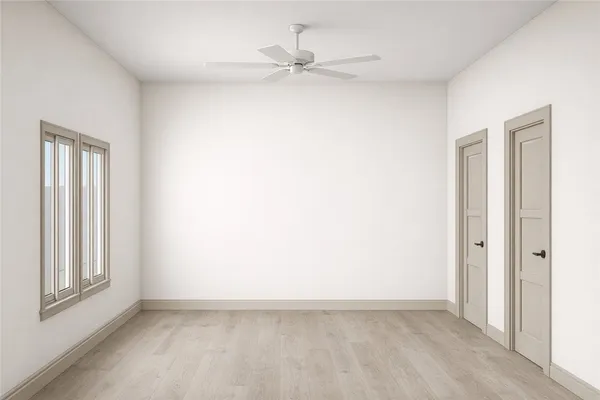 an empty room with a window and a fan