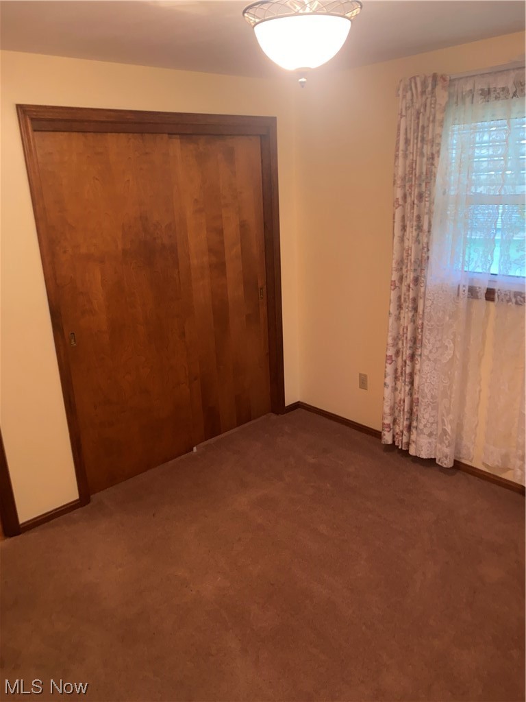 1518 Walnut Road Southwest Massillon, OH 44647 - Photo 7 of 26 Unfurnished bedroom featuring dark carpet and a closet