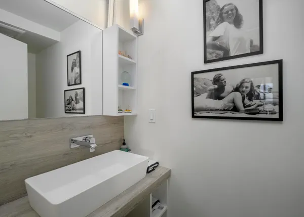 a bathroom with a sink and a painting on the wall