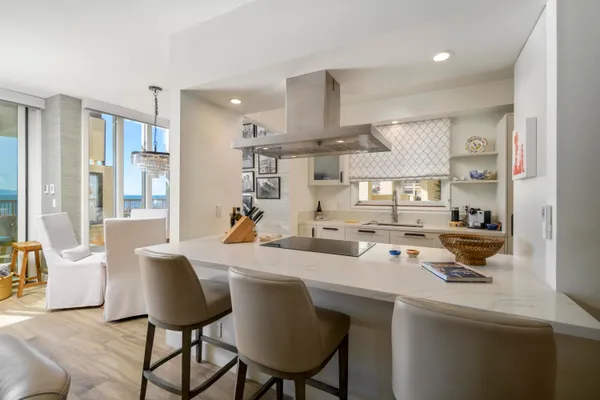 a dining room with stainless steel appliances a sink a table and chairs