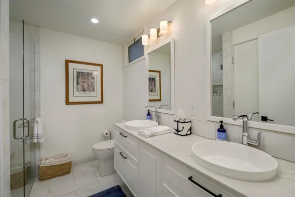 a bathroom with a double vanity sink mirror and toilet