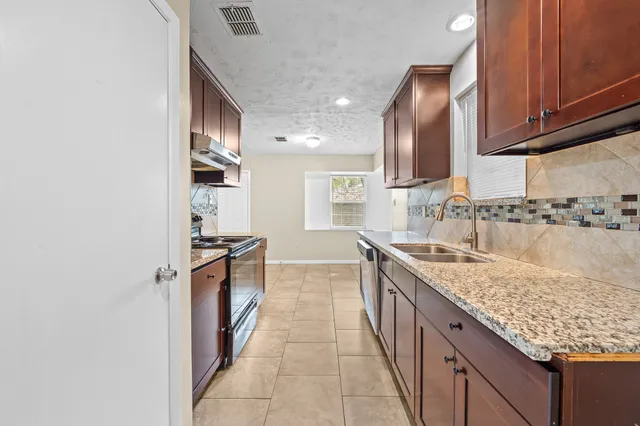 a kitchen with granite countertop sink and cabinets