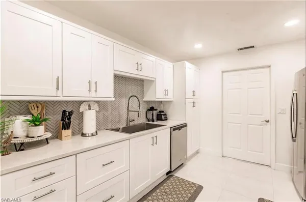 a kitchen with stainless steel appliances white cabinets and a sink
