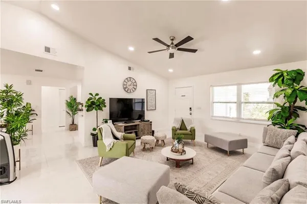 a living room with furniture a window and a flat screen tv