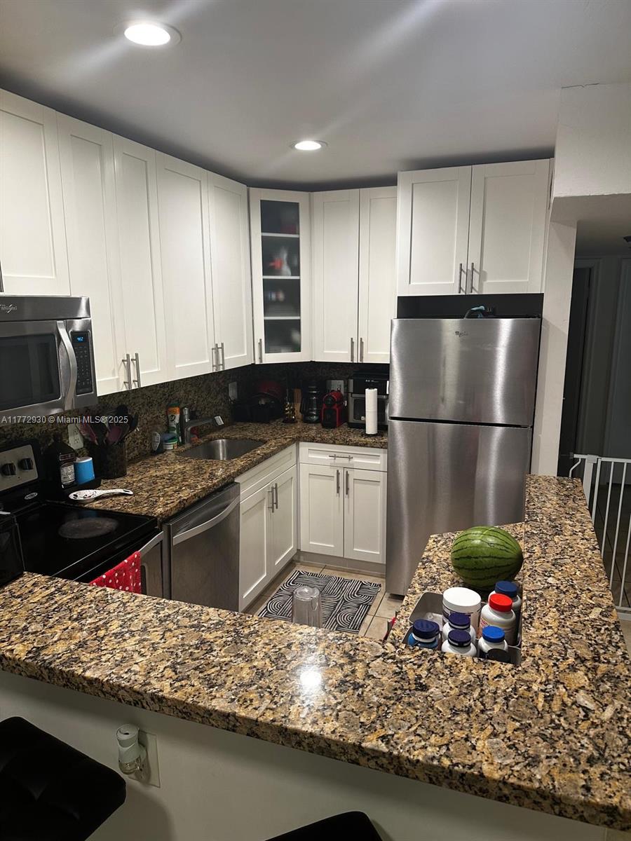 7951 Southwest 104th Street, Unit 210D Miami, FL 33156 - Photo 3 of 15 a kitchen with stainless steel appliances granite countertop a refrigerator sink and stove