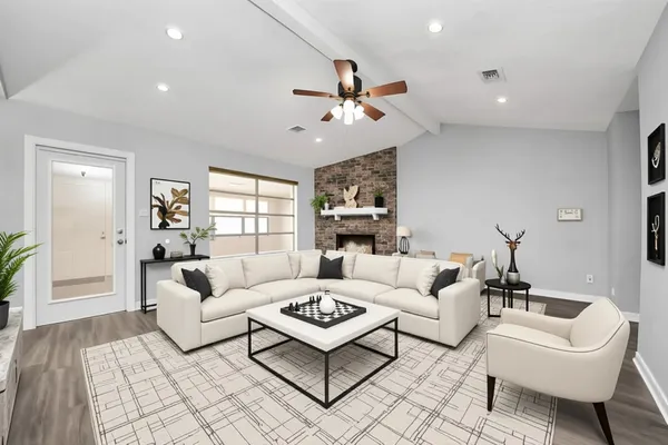 a living room with furniture a ceiling fan a rug and a window