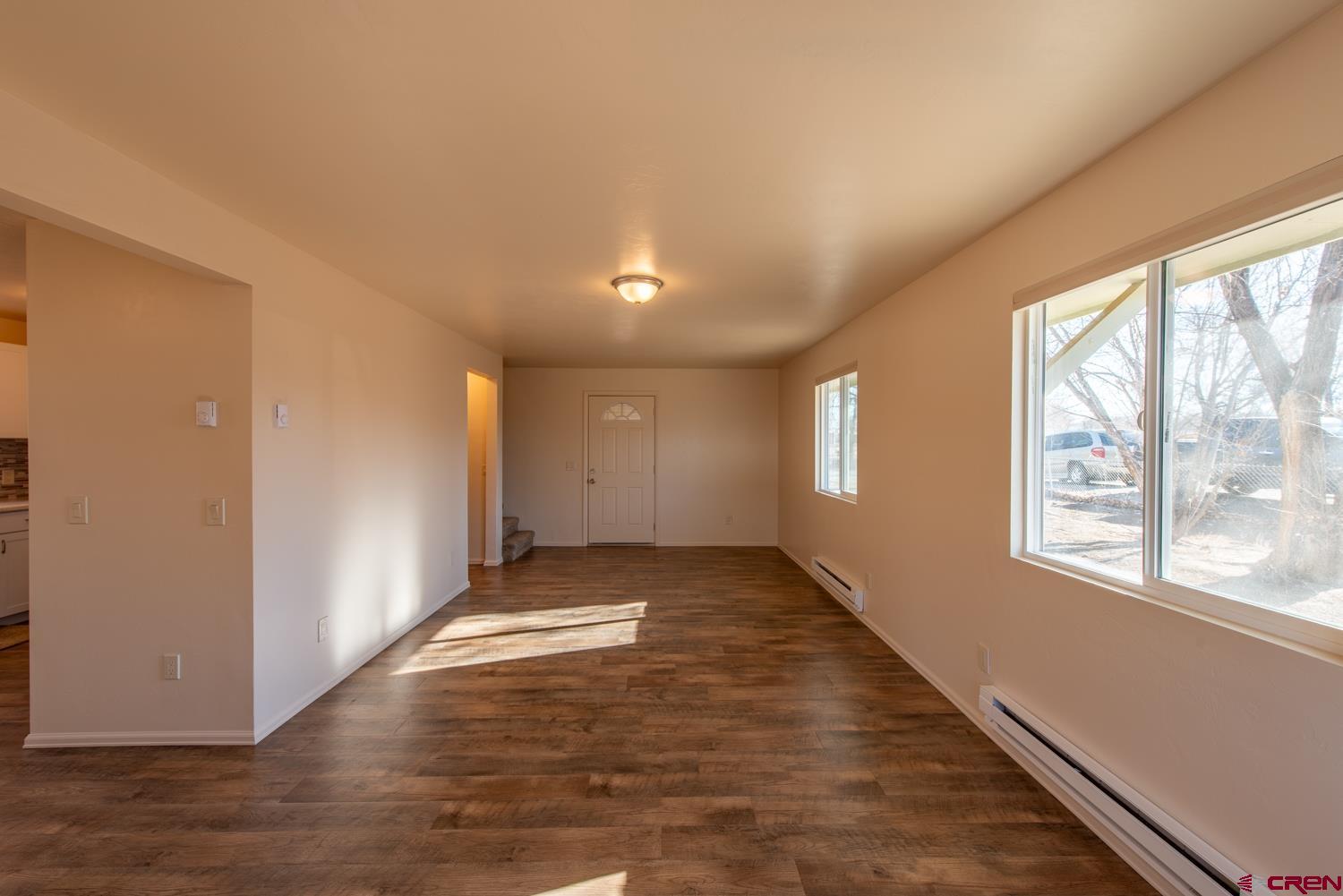 525 Elizabeth Street Delta, CO 81416 - Photo 14 of 30 an empty room with wooden floor and windows