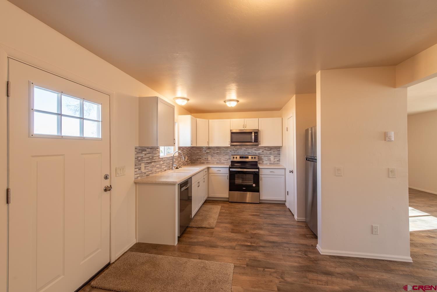 525 Elizabeth Street Delta, CO 81416 - Photo 6 of 30 a kitchen with stainless steel appliances a refrigerator and a stove top oven