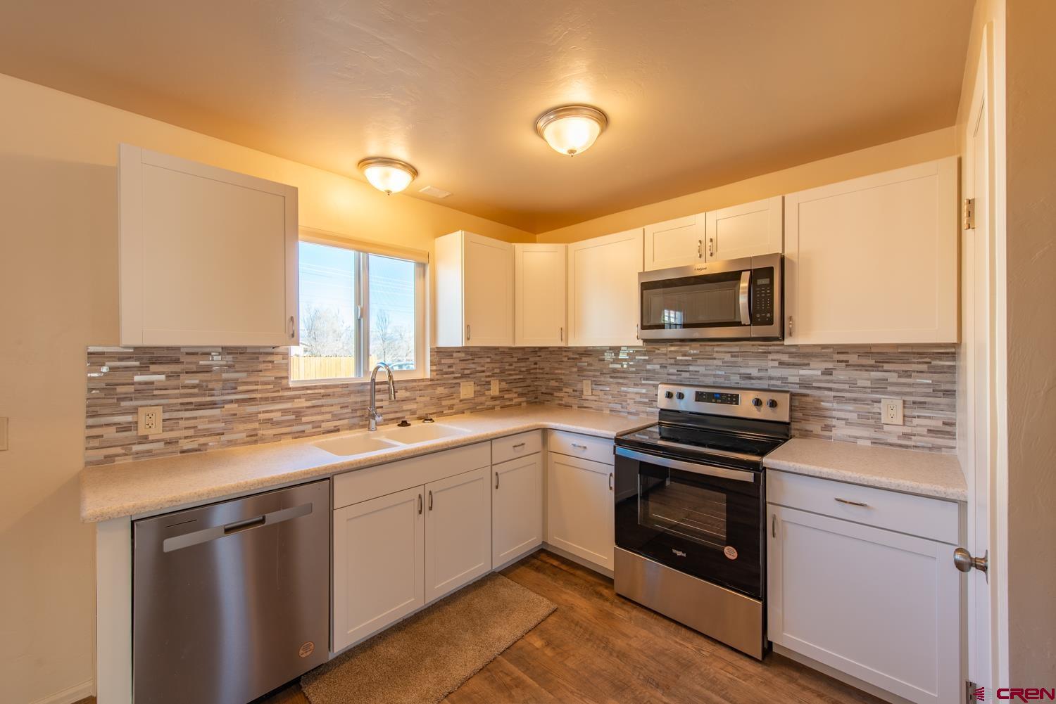 525 Elizabeth Street Delta, CO 81416 - Photo 7 of 30 a kitchen with stainless steel appliances granite countertop a stove and a microwave