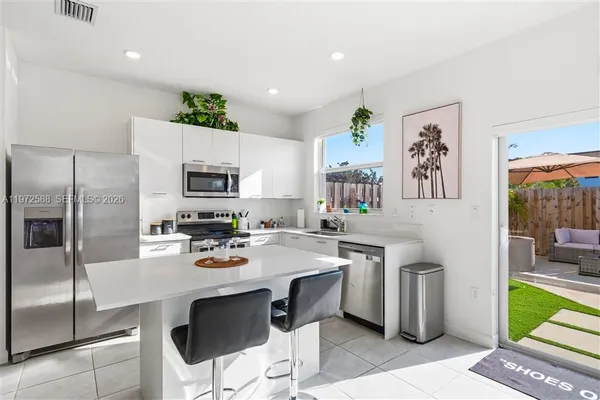 a kitchen with stainless steel appliances a sink a stove a refrigerator and cabinets