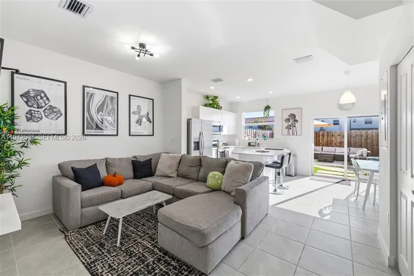 a living room with furniture and view of kitchen
