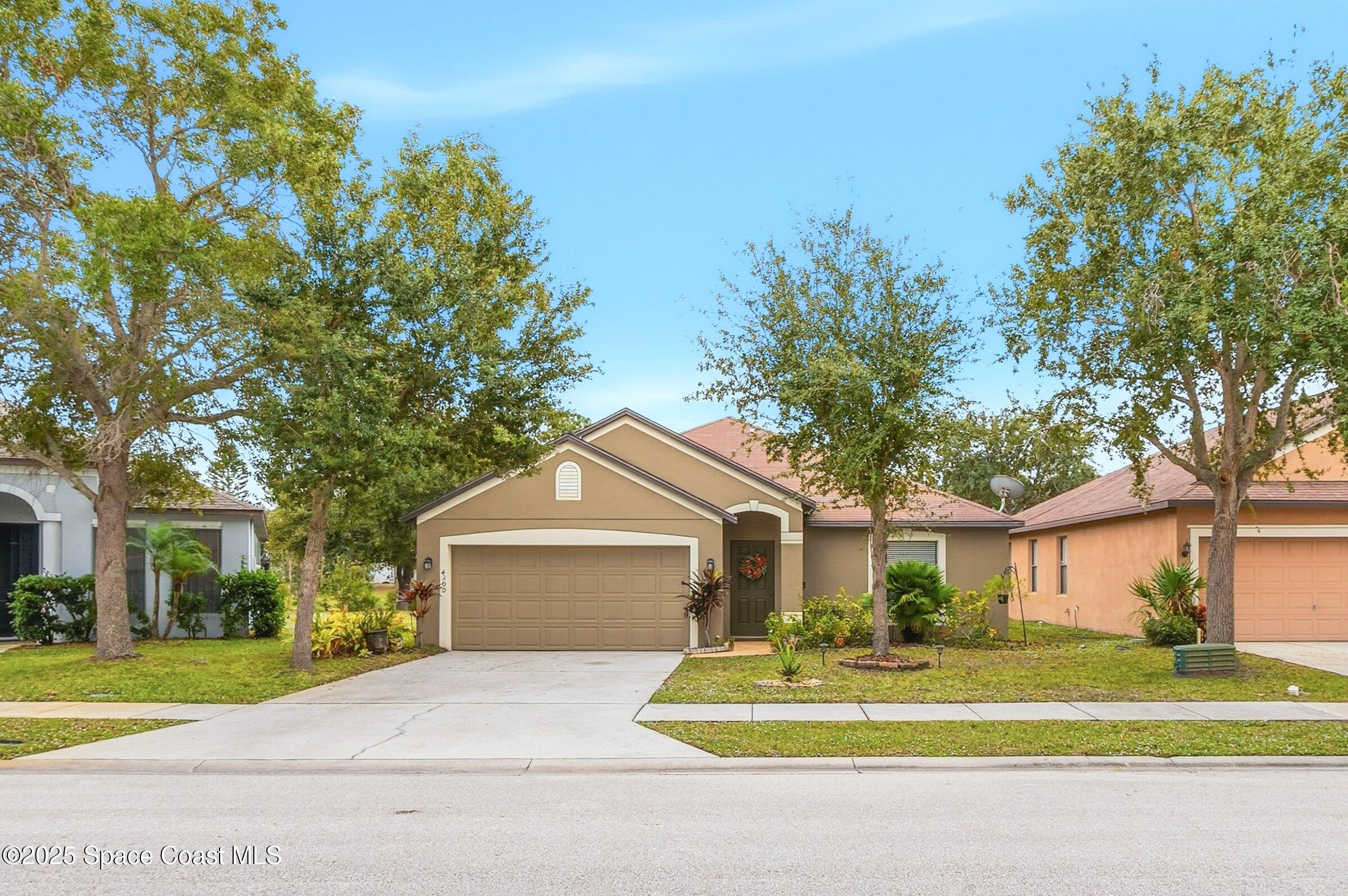 4300 Millicent Circle Melbourne, FL 32901 - Photo 28 of 29 a front view of a house with a garden and trees