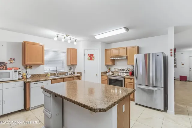 a kitchen with a center island appliances and cabinets