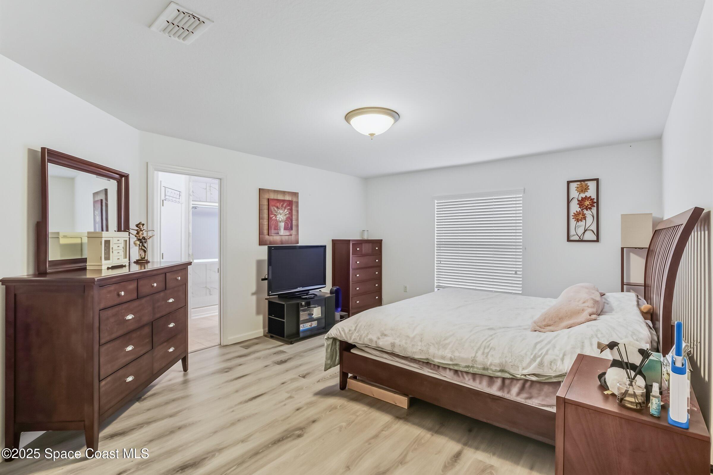 4300 Millicent Circle Melbourne, FL 32901 - Photo 4 of 29 a bedroom with a bed and furniture