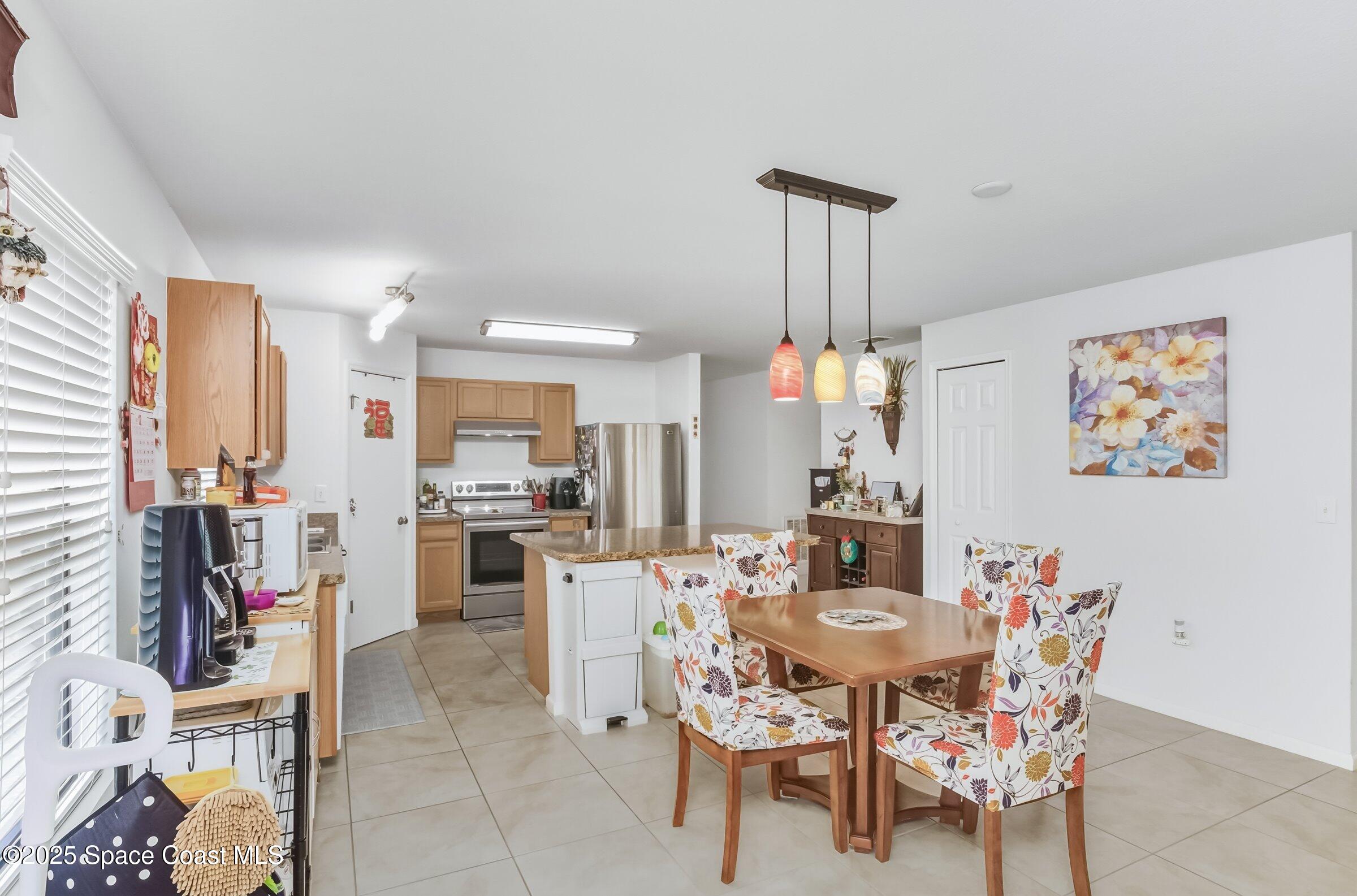 4300 Millicent Circle Melbourne, FL 32901 - Photo 9 of 29 a dining room with furniture and a chandelier