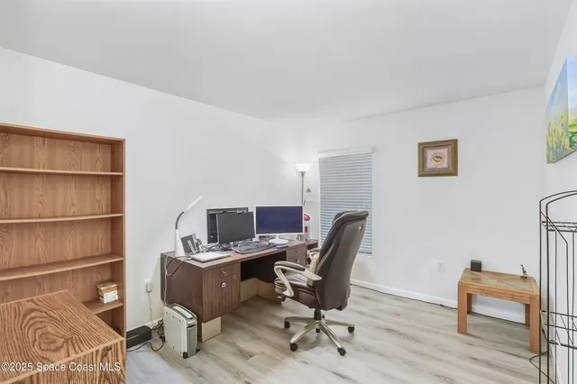 a view of a workspace with furniture and a window