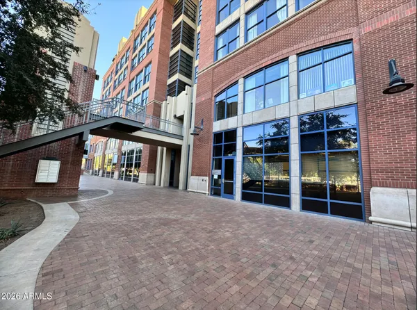 a view of building with a large window and potted plants