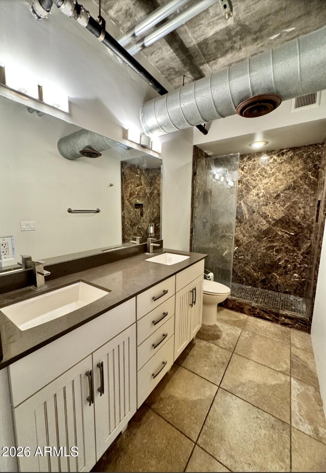 21 East 6th Street, Unit 306 Tempe, AZ 85281 - Photo 26 of 31 a bathroom with a granite countertop sink a toilet and a shower