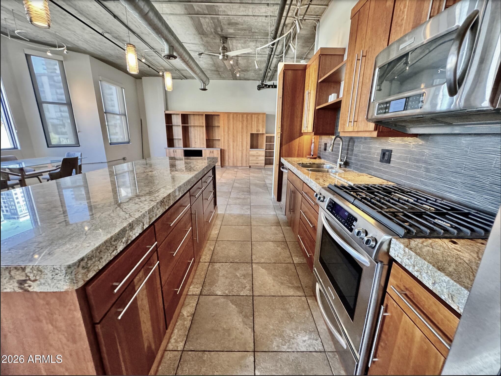 21 East 6th Street, Unit 306 Tempe, AZ 85281 - Photo 9 of 31 a kitchen with stainless steel appliances granite countertop a stove a sink and dishwasher