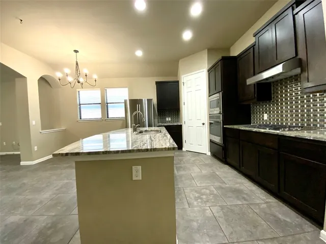 a kitchen with stainless steel appliances granite countertop a sink and cabinets