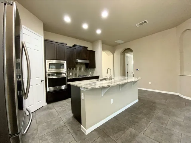a kitchen with stainless steel appliances a refrigerator sink and stove