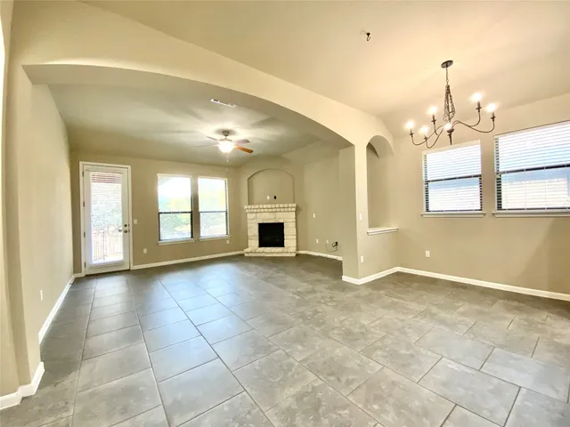 a view of an empty room with window and fireplace