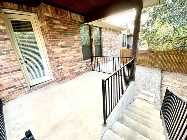 a view of a balcony with a floor to ceiling window and wooden fence