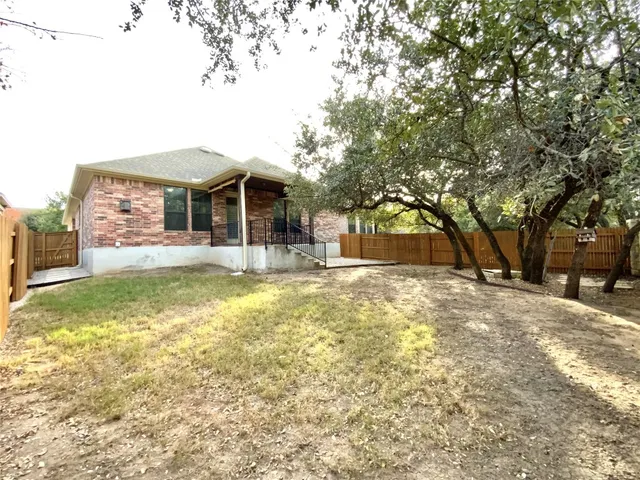 a front view of a house with a yard garage and a large tree
