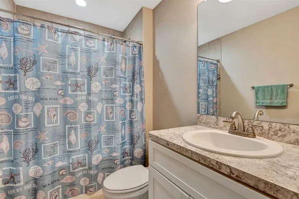 a bathroom with a granite countertop sink toilet and shower