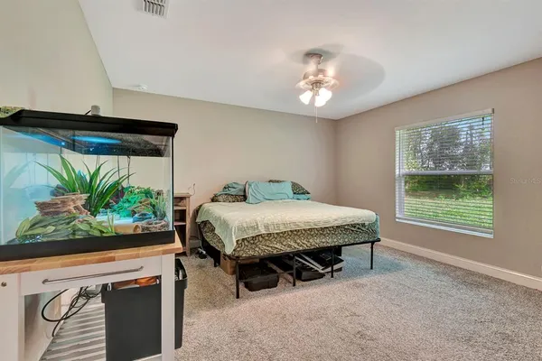 a spacious bedroom with a bed and a chandelier