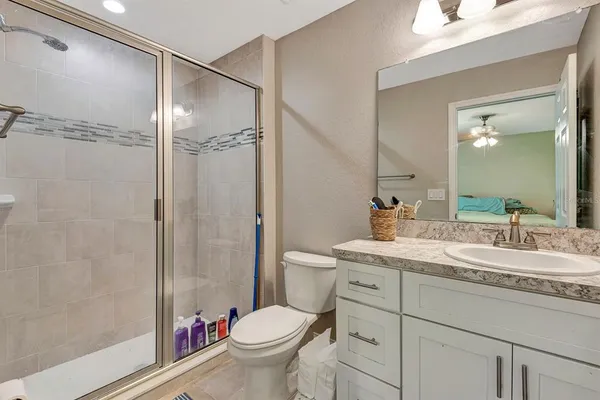 a bathroom with a granite countertop sink toilet and shower