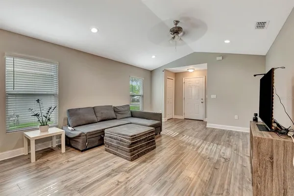 a living room with furniture a window and a flat screen tv