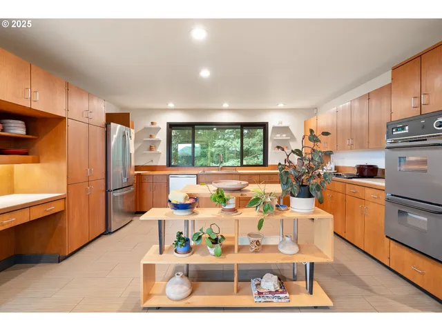 a kitchen with granite countertop a stove a sink and white cabinets with wooden floor
