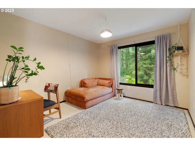 a living room with furniture a rug and a floor to ceiling window