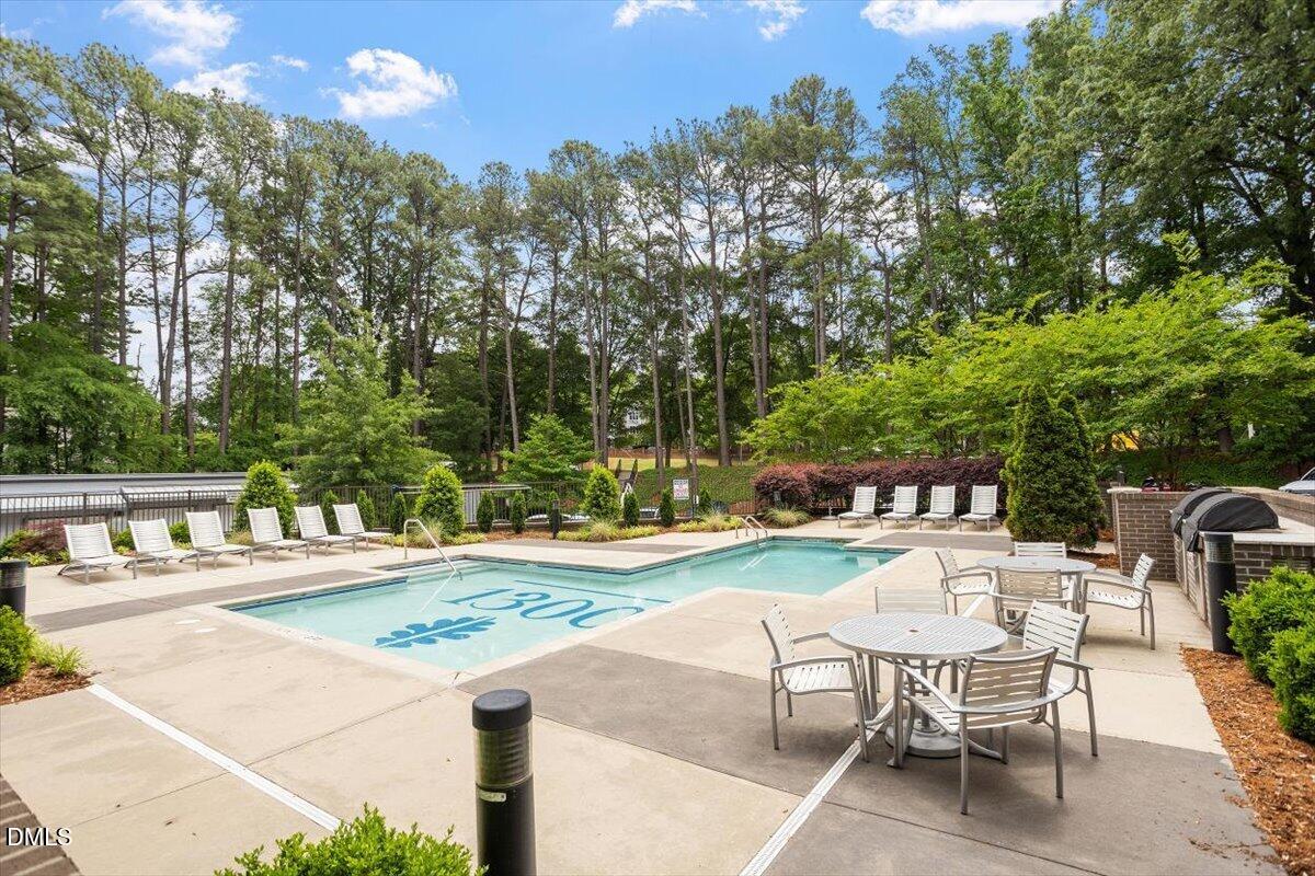 1300 St Marys Street, Unit 207 Raleigh, NC 27605 - Photo 21 of 31 a view of a swimming pool with a patio and a yard
