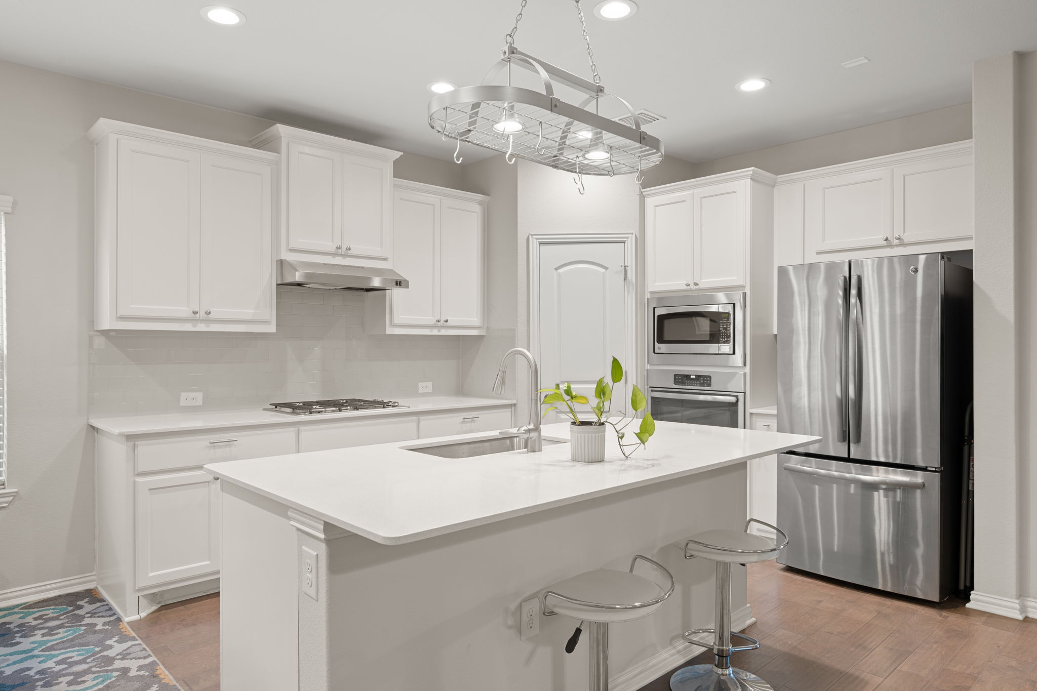 8800 Slater Drive Austin, TX 78747 - Photo 8 of 40 a kitchen with stainless steel appliances a sink a stove a refrigerator cabinets and chairs