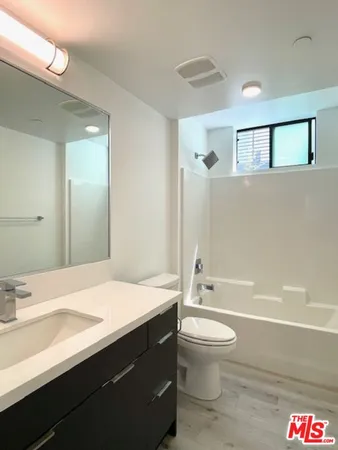 a bathroom with a sink a toilet and a large mirror
