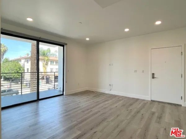 an empty room with wooden floor and sliding door