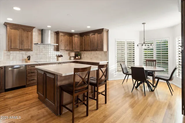 a kitchen with stainless steel appliances granite countertop a table chairs sink refrigerator and microwave