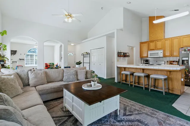 a dining room with granite countertop furniture a rug and a chandelier