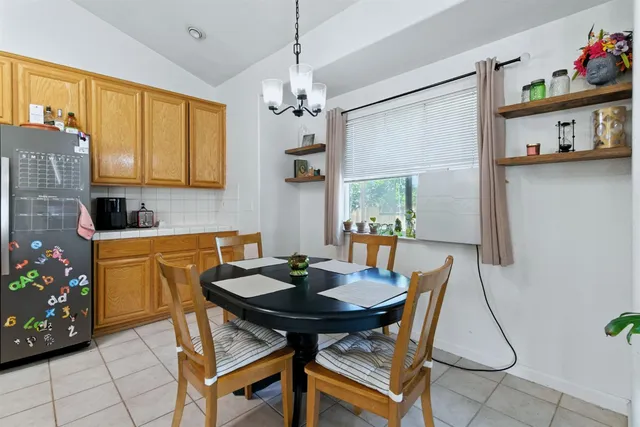 a kitchen with stainless steel appliances granite countertop a table chairs and a refrigerator