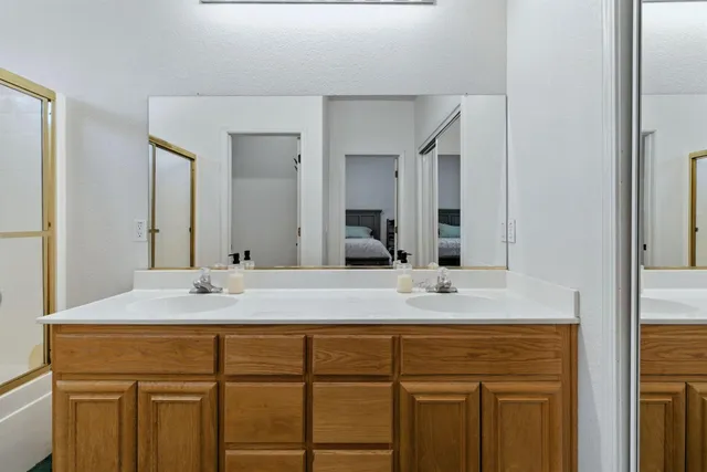 a bathroom with a shower sink and mirror
