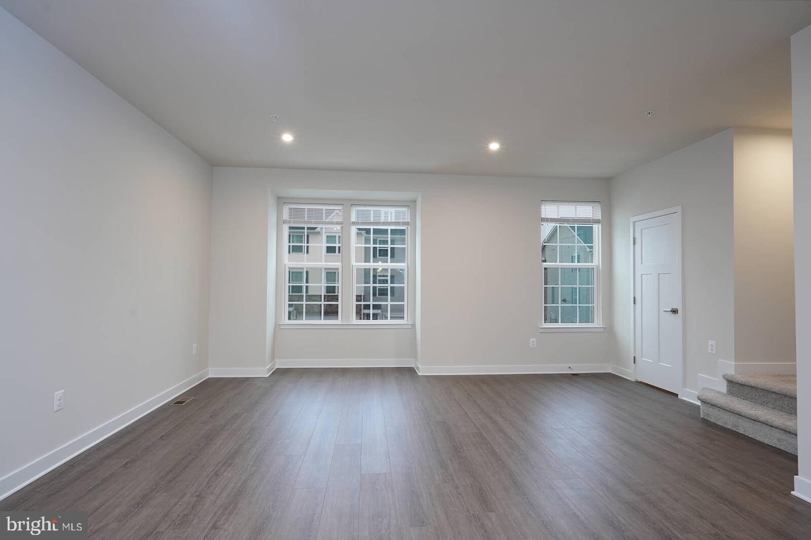 336 Paca Gardens Lane Frederick, MD 21703 - Photo 12 of 36 a view of an empty room with wooden floor and a window