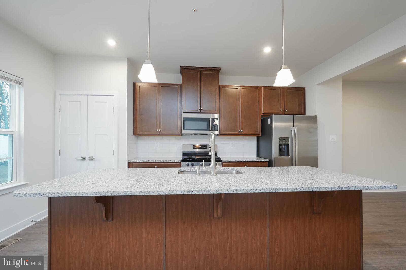 336 Paca Gardens Lane Frederick, MD 21703 - Photo 16 of 36 a kitchen with kitchen island granite countertop a sink a counter space appliances and cabinets