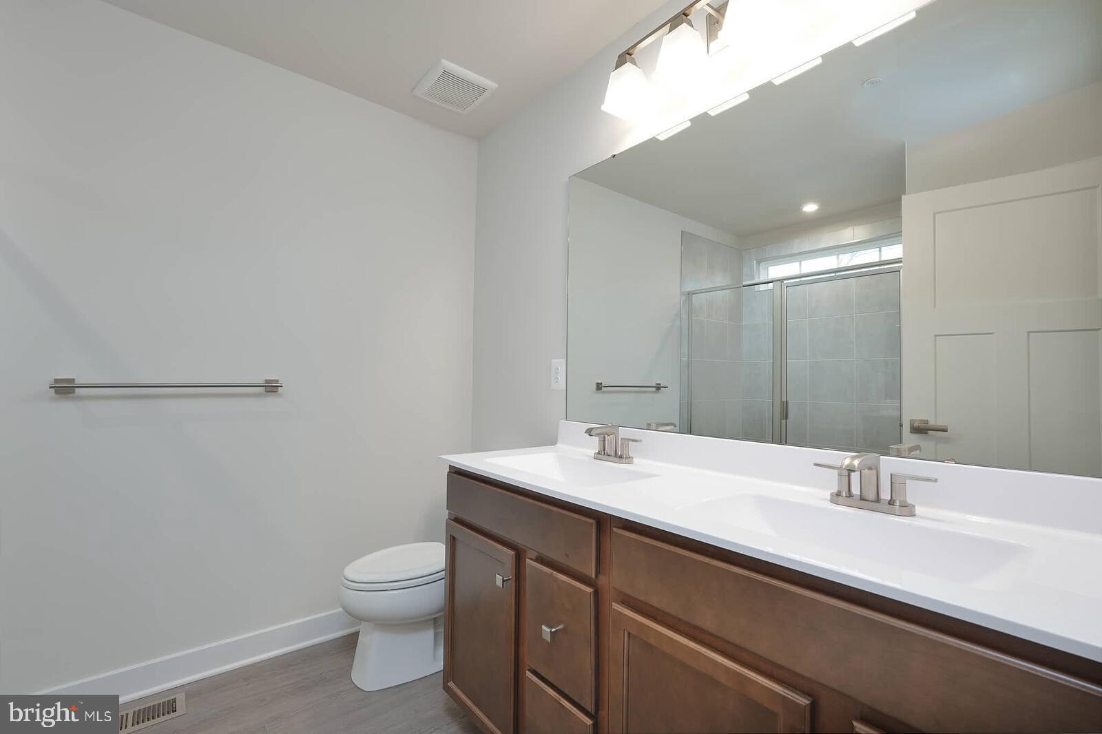 336 Paca Gardens Lane Frederick, MD 21703 - Photo 23 of 36 a bathroom with a toilet a sink and mirror